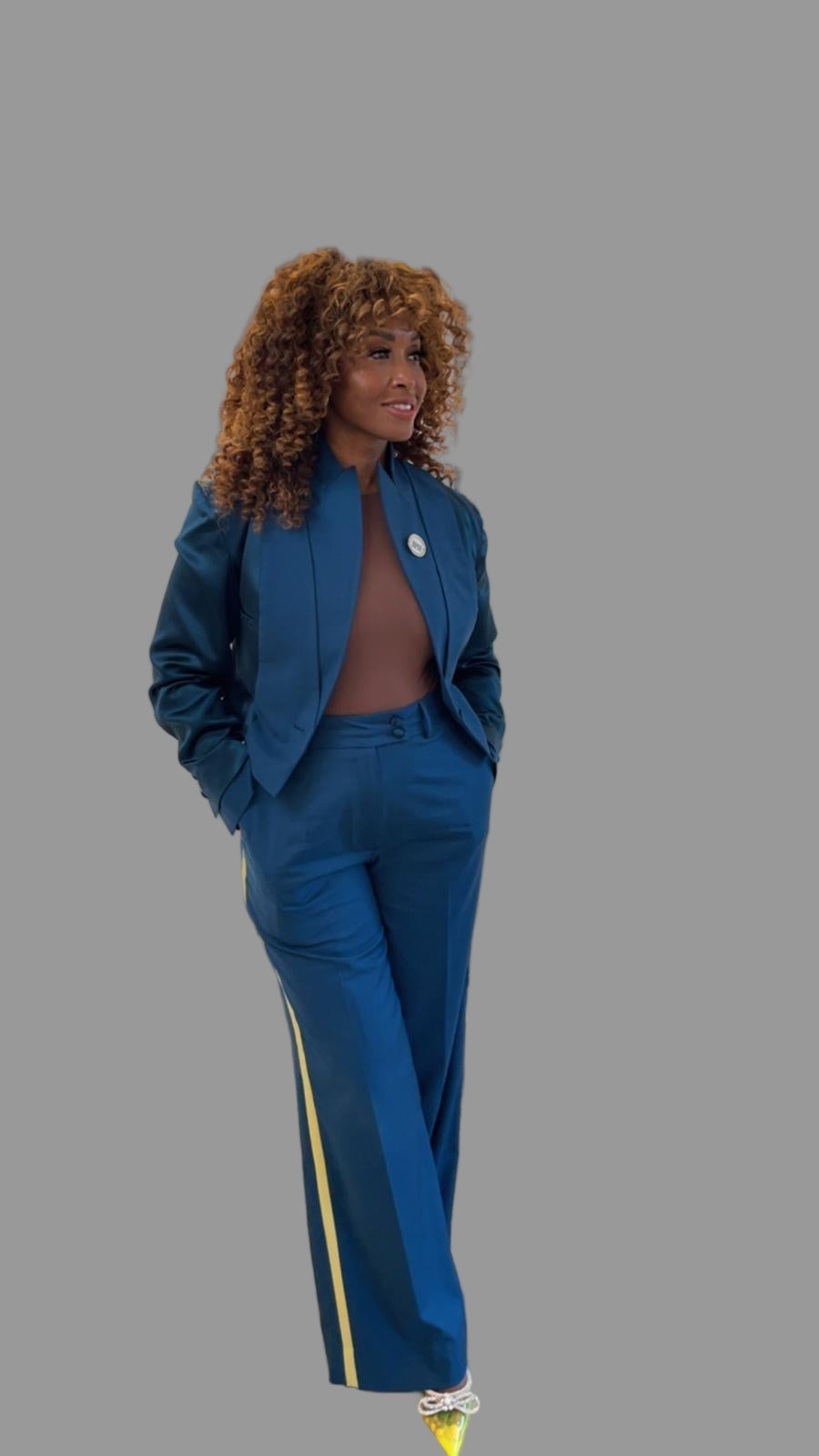 Woman in a blue suit standing in front of a wall with 'The Drip Bar' logo.